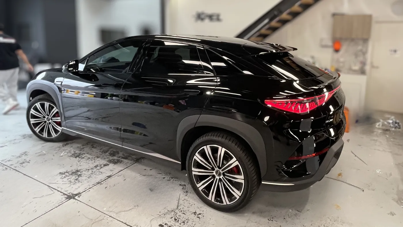 Black luxury SUV with tinted windows in a workshop